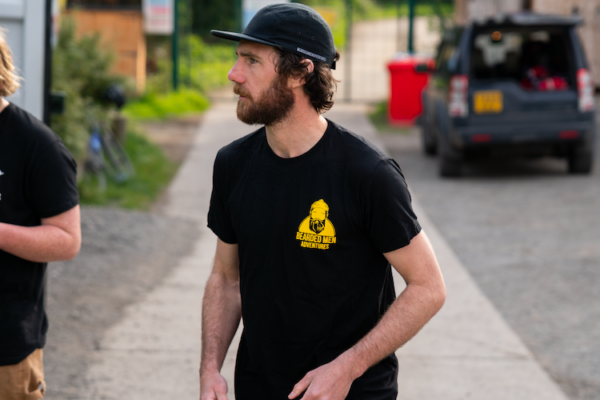 Man wearing bald t shirt with yellow Bearded Men Adventures logo on.