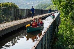 people canoeing over aqueduct in llangollen