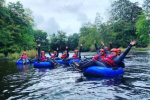 happy people river tubing in the river dee in llangollen