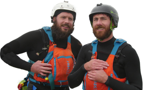 two men in helmets and wetsuits